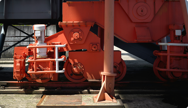 Industrial machinery with red hydraulic components and support structures.
